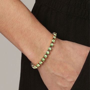 Photo of the DYRBERG/KERN Cory Bracelet (460089) featuring a radiant gold-tone finish with shimmering green crystals