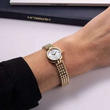 Photo of the Herbelin Perles 22mm Mother of Pearl Diamond Dial Quartz Yellow Gold PVD Watch 17433BP1N89, featuring a radiant gold-tone bracelet, lustrous MOP dial, and sparkling diamond hour markers