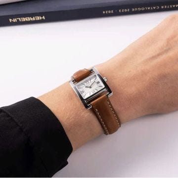 Photo of the Herbelin Ve Avenue 23.4mm Silver Dial Quartz Watch 17537AP08GD, featuring a sleek rectangular case, crisp silver dial, and rich brown leather strap