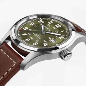 Photo of the Hamilton Khaki Field 42mm Green Dial Automatic Watch H70605560, featuring a bold green dial with luminous markers, day-date function, and a rich brown leather strap