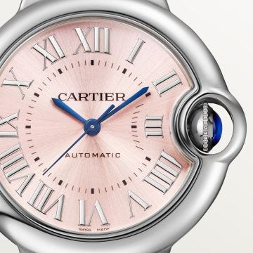 Photo of the Cartier Ballon Bleu de Cartier 33mm Pink Dial Automatic Watch WSBB0068, showcasing a soft pink sunray dial, fluted crown with blue cabochon, and polished stainless steel bracelet